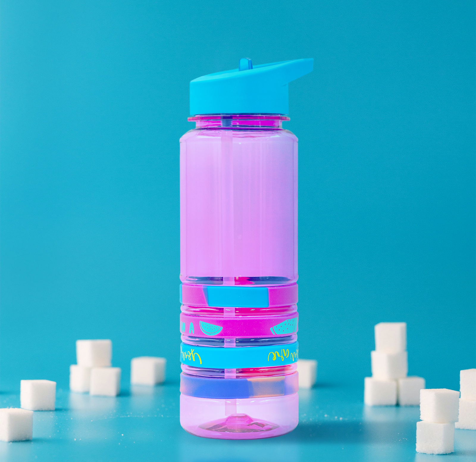 The after image of a pink and blue water bottle surrounded by sugar cubes.