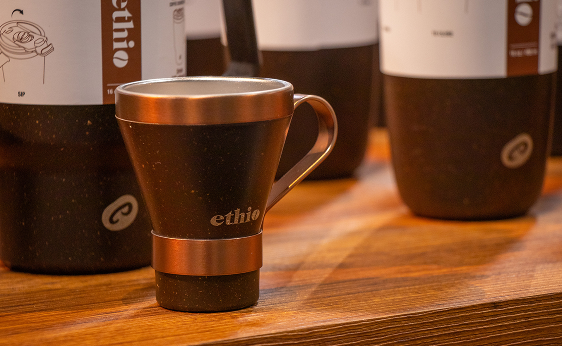 An Ethio coffee mug displayed on a table with other Ethio products in the background.