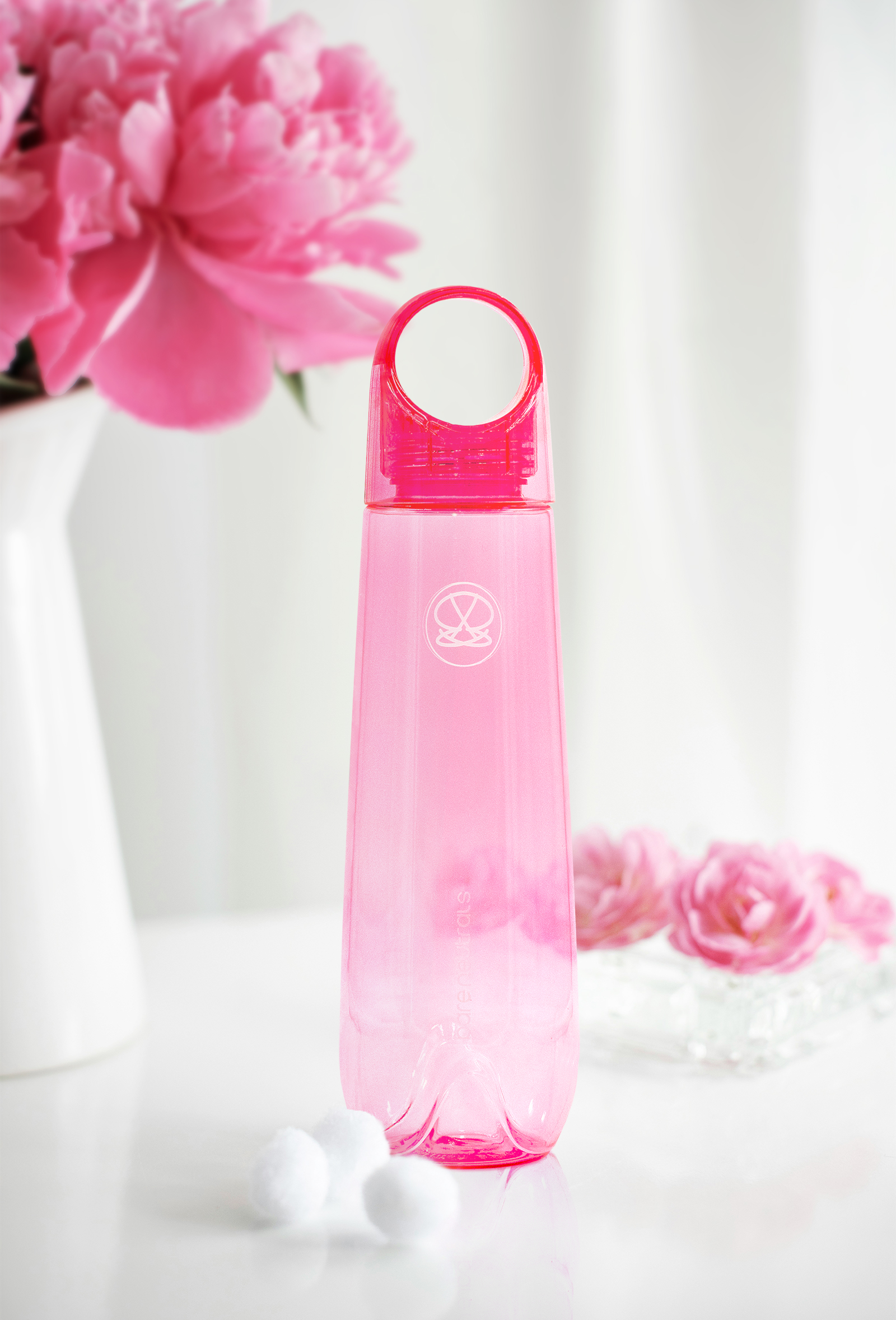 The after image of a pink water bottle with flowers in the background.