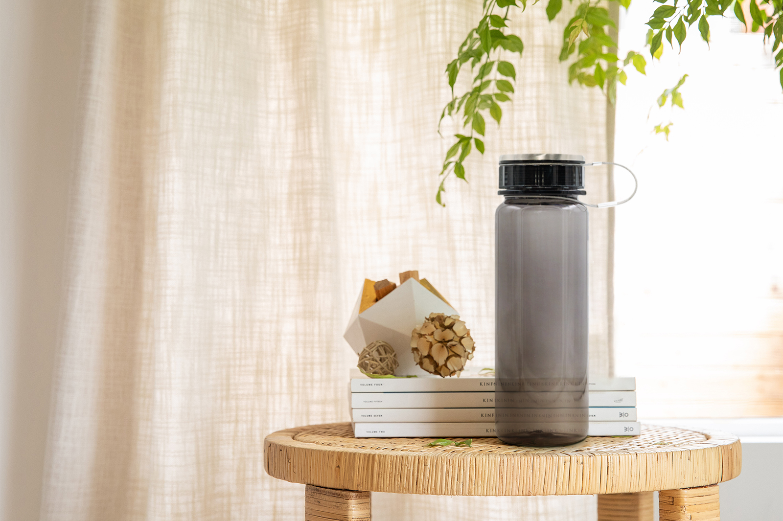 The after image of a black water bottle on a wicker table.