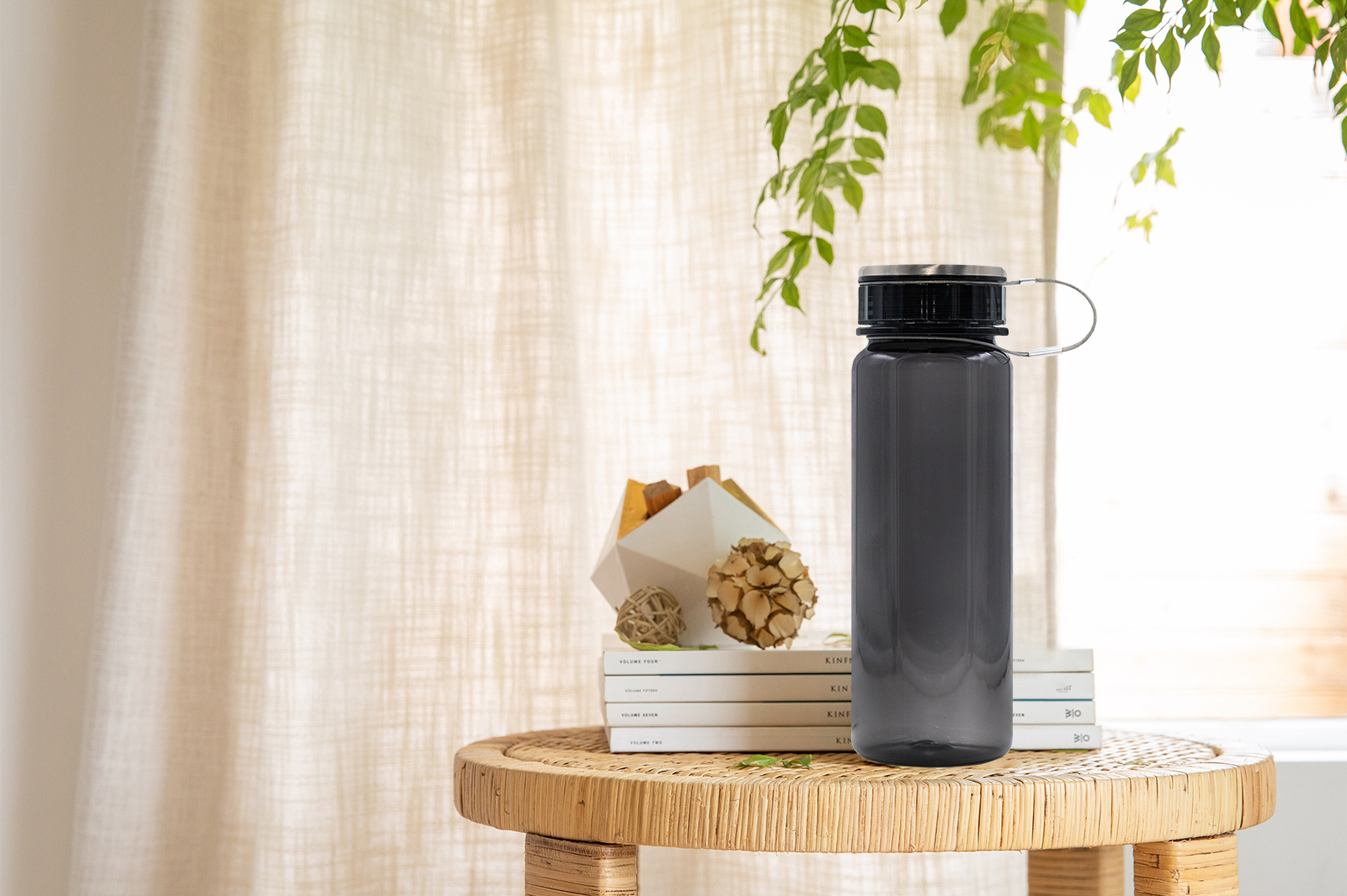 The before image of a black water bottle on a wicker table.